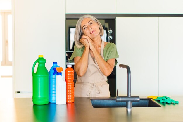 Middle age woman feeling in love and looking cute, adorable and happy, smiling romantically with hands next to face