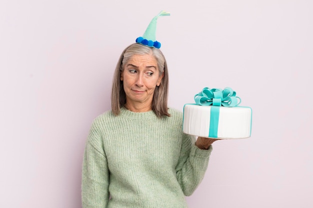 Middle age woman feeling sad upset or angry and looking to the side bitrthday cake concept