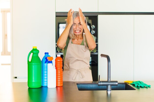 Middle age woman feeling stressed and anxious, depressed and frustrated with a headache, raising both hands to head