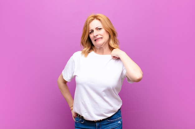 Middle age woman feeling stressed, anxious, tired and frustrated, pulling shirt neck, looking frustrated with problem