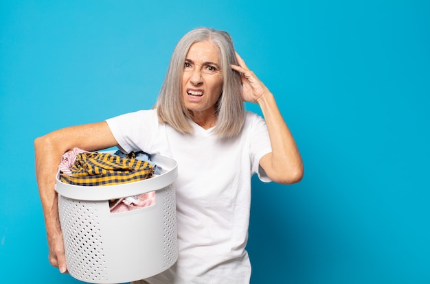 middle age woman feeling stressed, worried, anxious or scared, with hands on head, panicking at mistake