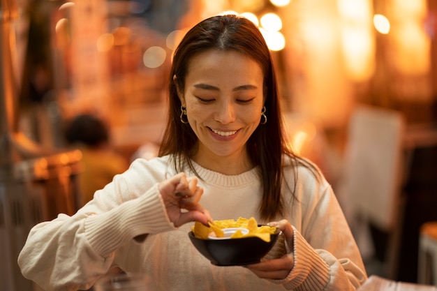 写真 レストランで楽しんでいる中年女性