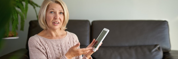 Middle age woman holding computer at home.