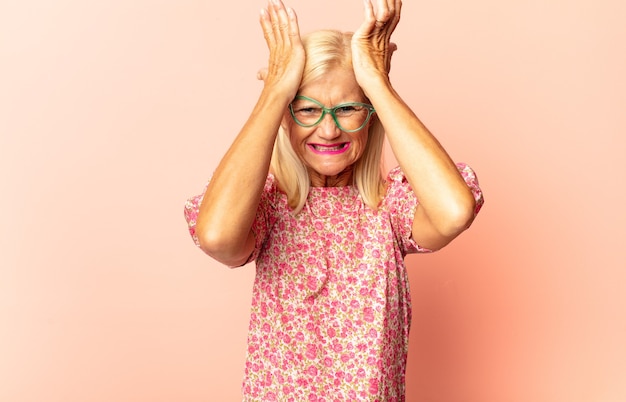 Middle age woman holding an object with both hands isolated