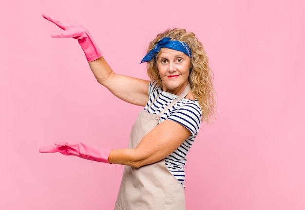 Middle age woman holding an object with both hands on side