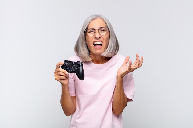 Middle age woman looking angry, annoyed and frustrated. playing console concept