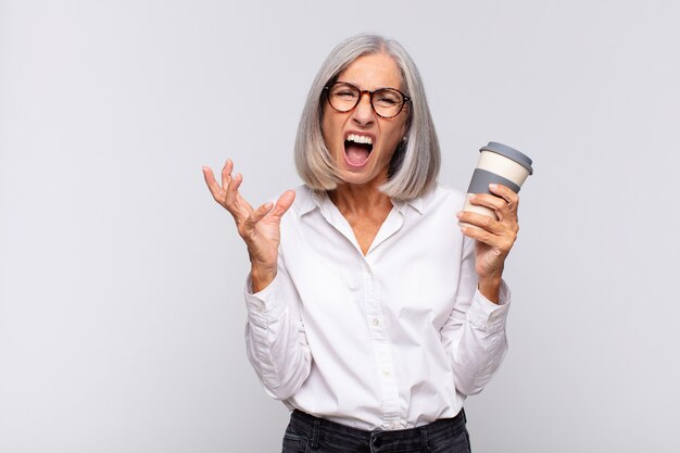 Middle age woman looking angry, annoyed and frustrated screaming wtf or whatâÃÃ´s wrong with you coffee concept