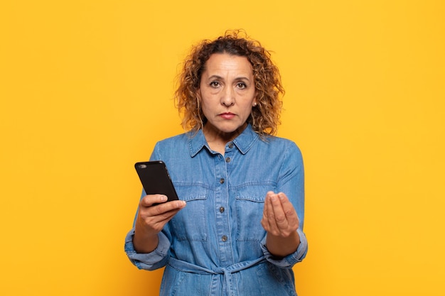 Middle age woman making capice or money gesture