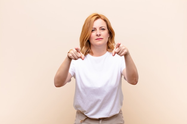 Middle age woman pointing forward with both fingers and angry expression, telling you to do your duty