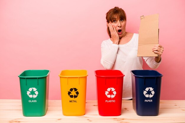 Middle age woman recycling isolated on pink background