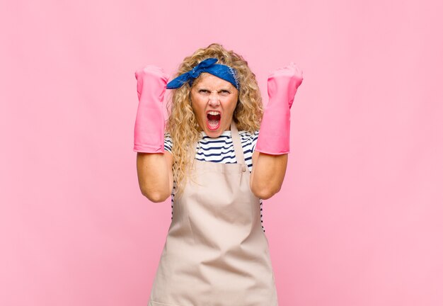 Middle age woman shouting aggressively with an angry expression