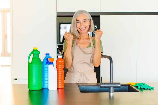 Middle age woman shouting triumphantly, laughing and feeling happy and excited while celebrating success