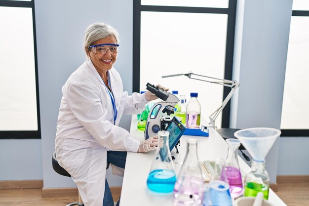 Photo middle age woman wearing scientist uniform watching embryo on touchpad at laboratory