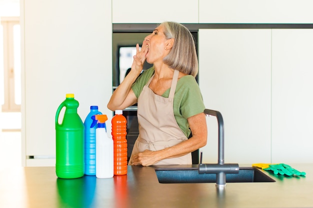 Middle age woman yelling loudly and angrily to copy space on the side, with hand next to mouth