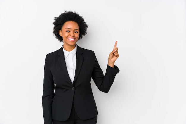 Middle aged african american business  woman against a white wall isolated smiling cheerfully pointing with forefinger away.