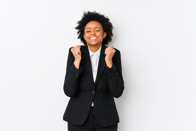 中年のアフリカ系アメリカ人ビジネスの女性は白で隔離された調達の拳で、幸せと成功を感じています。