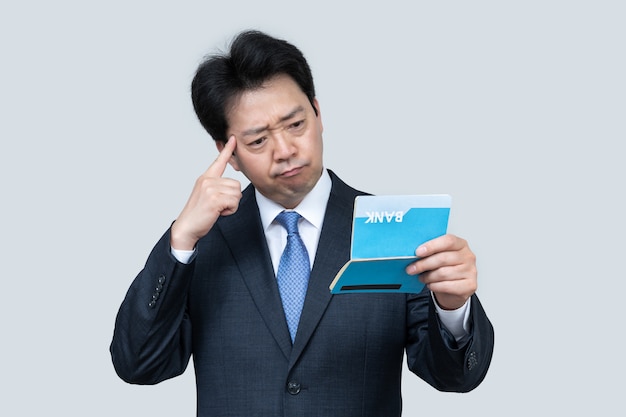 Middle-aged Asian man holding a bank passbook