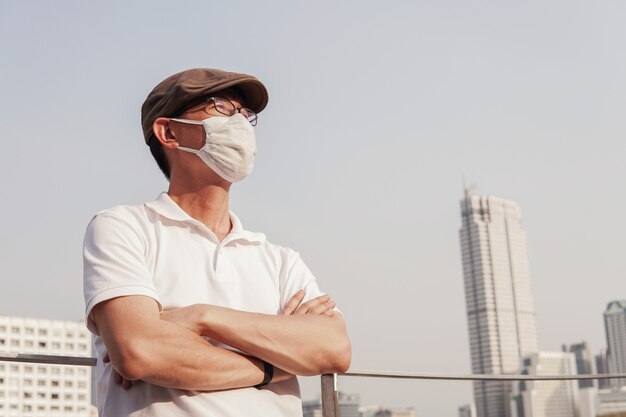 Middle aged Asian man wearing glasses and medical face mask,  Wuhan coronavirus outbreak, air pollution and health concept