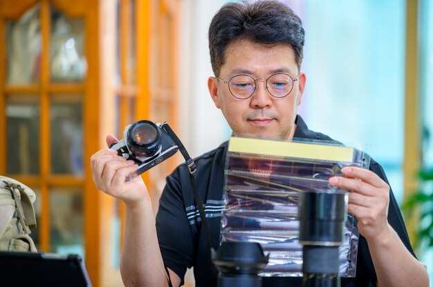 A middle-aged asian man whose hobby is 35mm/135mm film slr camera