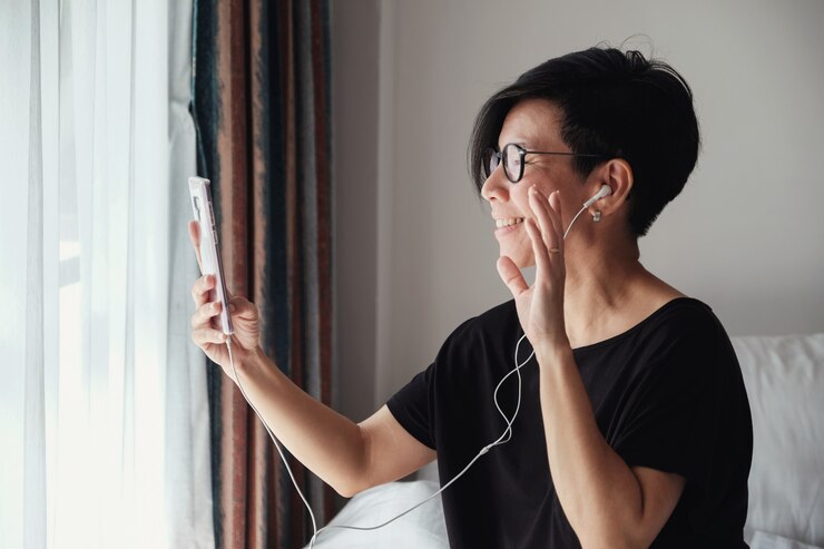 Photo ビデオ通話を自宅で作る中年のアジア女性
