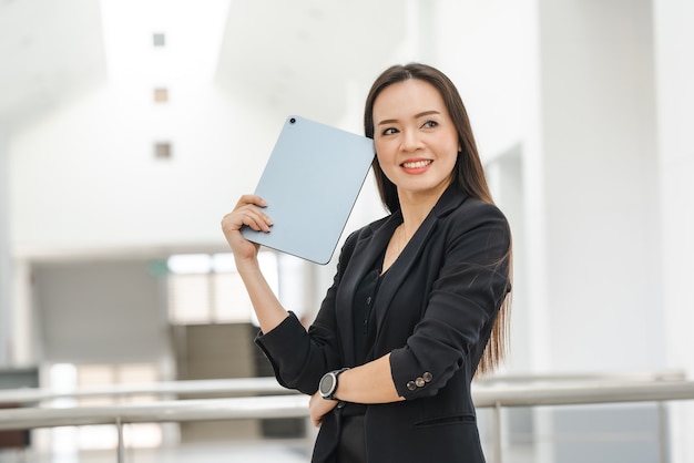 A middle-aged Asian woman teacher holding a tablet at University