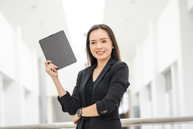 A middle-aged Asian woman teacher holding a tablet at University