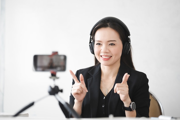 A middle-aged Asian woman teacher live online with smartphone at University