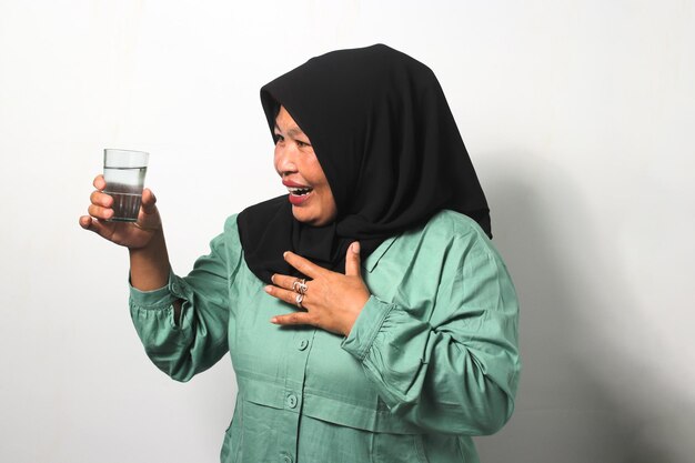 Middle aged Asian women wearing hijab feels so thirsty during ramadan fasting