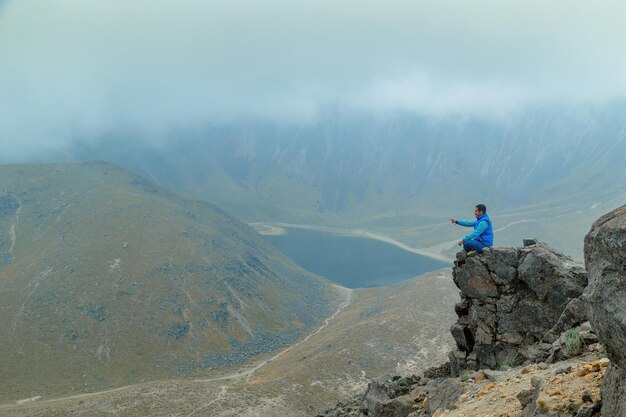 A middle aged backpacker looking over the Quilotoa volcanic crater lagoon