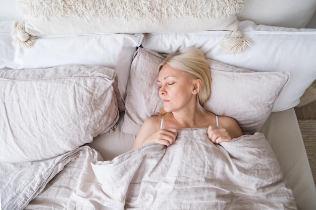 Middle aged blonde beautiful woman sleeps. wellness at\
home.