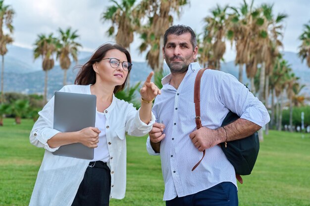 Middle aged business colleagues talking in the park