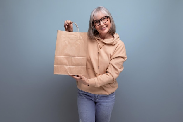 Middle aged business woman with gray hair holding a package for retirement insurance on a studio