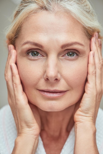 Middle aged caucasian woman with hands near face