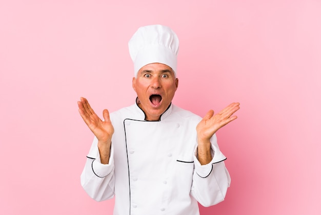 Middle aged cook man isolated surprised and shocked.