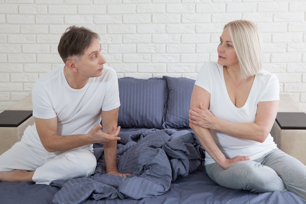 Middle aged couple in quarrel in bed