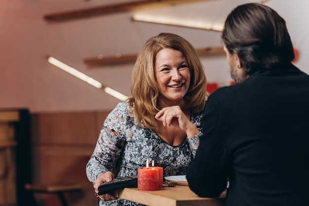 A middle-aged couple at a table in a cafe on Valentine's Day