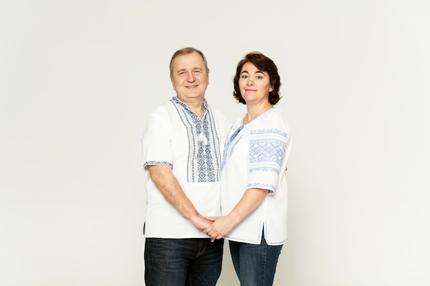 Middle-aged couple in Ukrainian costumes on a white background. a man and a woman in embroidered shirts.