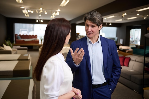 A middle aged European couple chooses upholstered furniture in a furniture mall