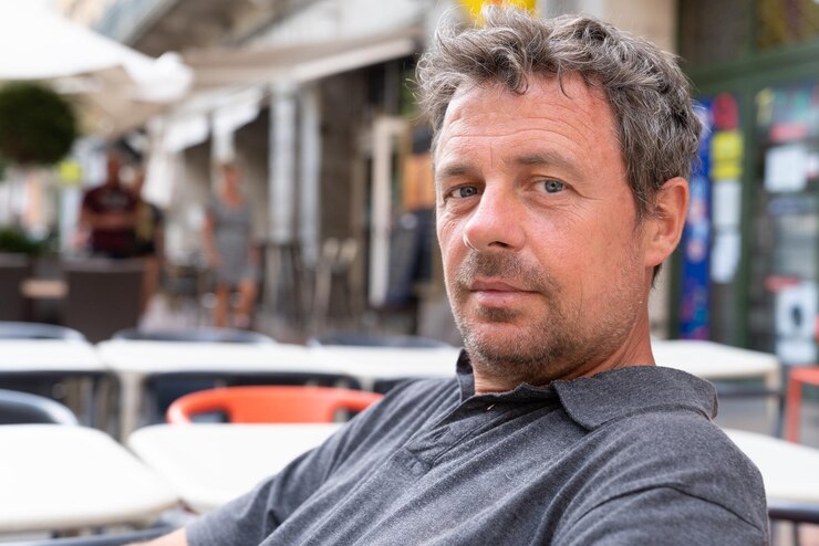 Middle aged handsome man sits outdoor cafe terrace