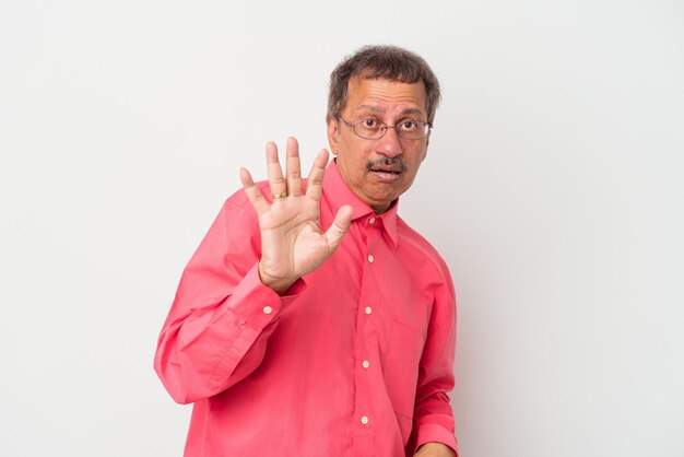 Middle aged indian man isolated on white background being shocked due to an imminent danger
