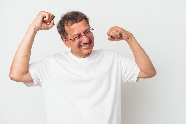 Middle aged indian man isolated on white background celebrating a special day, jumps and raise arms with energy.