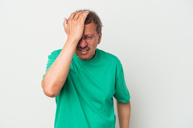 Middle aged indian man isolated on white background forgetting something, slapping forehead with palm and closing eyes.