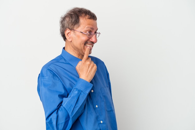 Middle aged indian man isolated on white background relaxed thinking about something looking at a copy space.