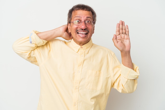 Middle aged indian man isolated on white background screaming with rage.