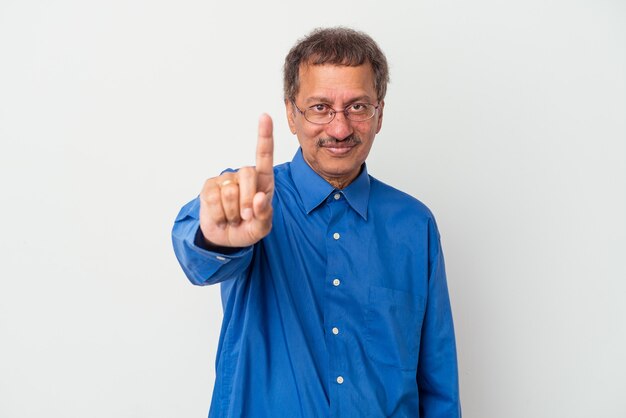 指でナンバーワンを示す白い背景に分離された中年のインド人男性。