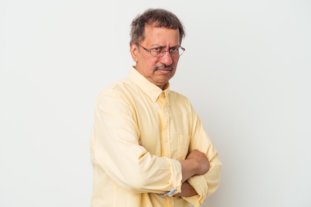 Middle aged indian man isolated on white background suspicious, uncertain, examining you.