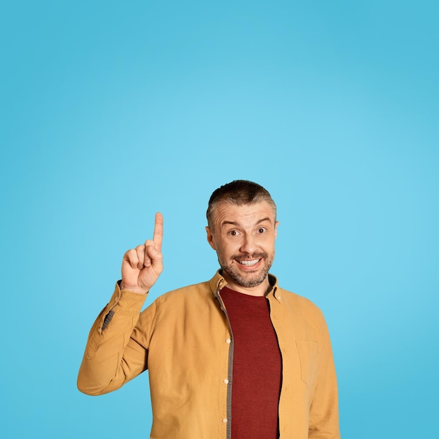 Middle Aged Male Pointing Finger Up Having Idea Blue Background