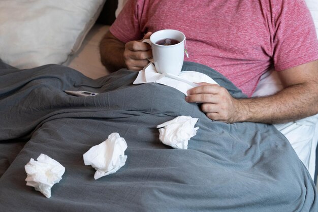 독감 증상으로 아파서 침대에 누워 있는 중년 남자.