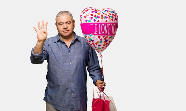 Middle aged man celebrating valentines day showing number four