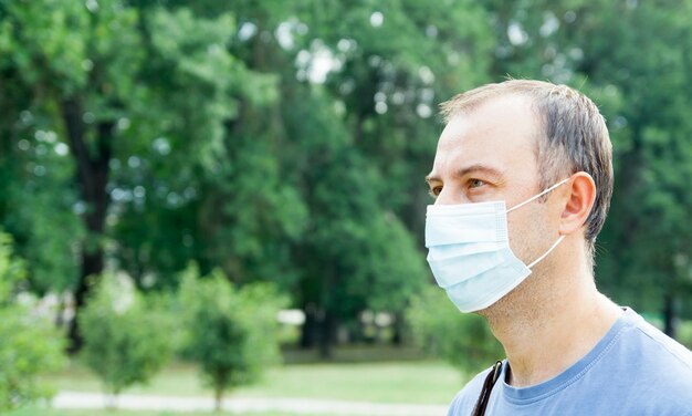 Middle-aged man in a medical mask outdoors